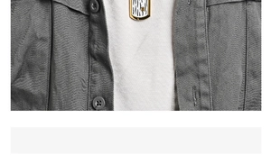Macro view of a gold-rimmed rectangular pendant with zebra pattern on a gray shirt