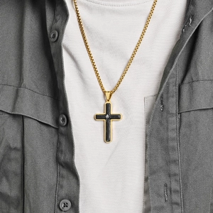 Men's gold-plated cross necklace with black carbon fiber inlay worn on a model