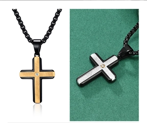 Macro detail of cross pendant featuring brushed metal texture and inlaid crystal