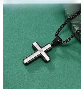 Macro shot of two-tone stainless steel cross pendant with a centered white zircon stone
