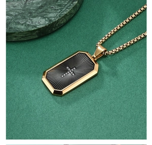Close-up of gold tone octagon pendant with black sunburst texture and zircon cross detail