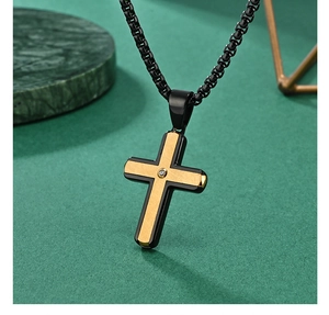 Close-up of two-tone cross pendant with gold brushed texture and center cubic zirconia