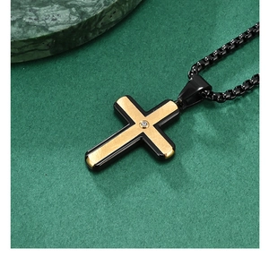 Detailed macro of a two-tone cross pendant with brushed gold finish and small diamond inlay