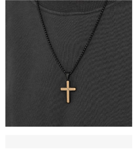 Close-up of two-tone cross pendant with brushed metal texture and a small center diamond