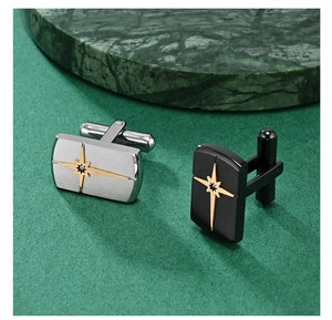 Macro detail of men's stainless steel cufflinks with star motif on green marble surface