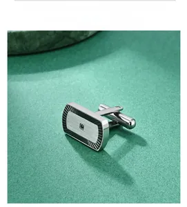 Detailed macro view of silver rectangle cufflinks with black radial texture and square gemstone
