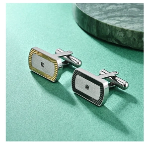 Macro shot of silver cufflinks with fan texture, gold accents and square inlaid crystals