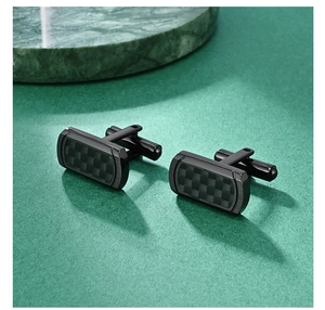 Close-up of black carbon fiber cufflinks with a brushed metal finish for men's shirts