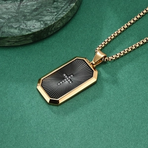 Gold rectangular pendant necklace with black fan texture and zircon cross charm on green background