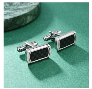 Detail of luxury carbon fiber cufflinks with square checkered pattern on green background