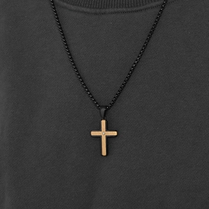 Two-tone brushed steel cross pendant necklace with zircon stone on dark fabric