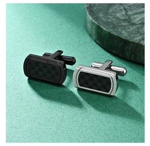 Macro shot of silver men's cufflinks with black carbon fiber checkered inlay design