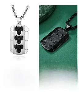 Detail of silver and black stainless steel pendants with hexagonal carbon fiber inlays