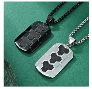 Detail of military tag pendant with carbon fiber honeycomb texture and brushed steel
