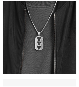 Close-up of men's steel necklace with vertical carbon fiber heart inlay on dog tag