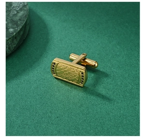 Macro detail of golden men cufflink with world map relief and black zircon accents