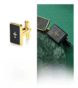 Macro view of rectangular gold and black cufflinks featuring a metallic cross design