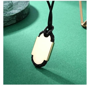Détail macro du pendentif géométrique en titane pour homme avec cordon en cuir tressé