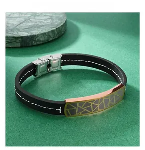 Detail of black fiber leather strap with golden geometric engraved plate and steel clasp