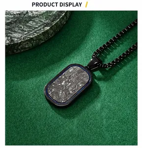 Dettaglio del ciondolo dog tag in fibra di carbonio forgiata con bordo blu su catena nera