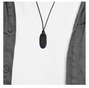 Détail du pendentif ovale noir mat avec bordure en cuir bleu tressé sur cordon
