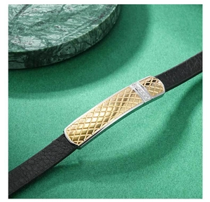Détail macro du bracelet en cuir pour homme avec insert en métal doré et maillons polis
