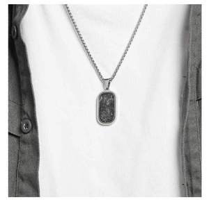 Close-up of minimalist carbon fiber military tag pendant on silver chain for men