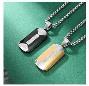 Detail of men's black and gold military dog tag pendants with geometric texture