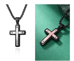 Détail d'un pendentif croix en acier inoxydable bicolore avec fixations par rivets