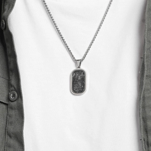 Minimalist men's dog tag necklace with carbon fiber inlay worn on a casual shirt