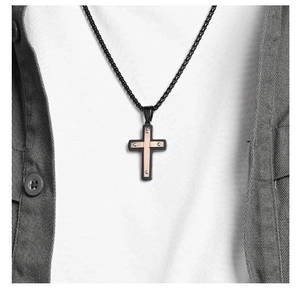 Détail du pendentif croix bicolore en acier inoxydable avec cristaux porté par un mannequin