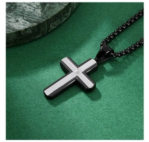 Detailed macro view of a two-tone cross pendant with a center-set zircon on a box chain