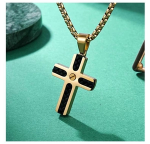 Detailansicht goldener Kreuzanhänger mit schwarzem Lederinlay und Schraubendetail