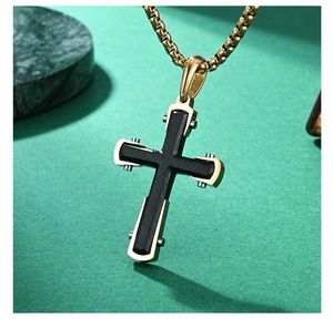 Détails de ce pendentif croix bicolore or et noir avec rivets et chaîne carrée