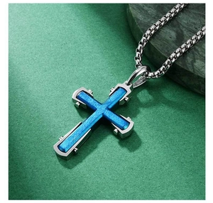 Détail du pendentif croix avec texture brossée bleu foncé et chaîne à maillons carrés