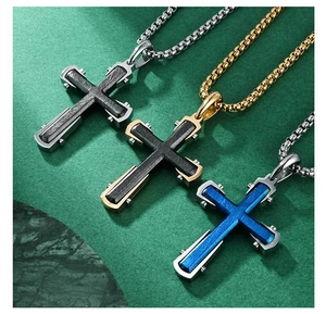 Vue détaillée des pendentifs croix bicolores avec texture brossée et chaînes à mailles