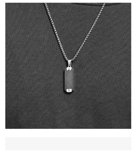 Detailed view of square military tag necklace with brushed metal finish on box chain