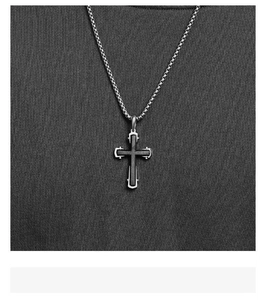 Détail du pendentif croix avec texture mate industrielle et finition gris fusil