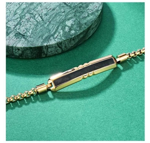 Macro detail of men's gold faceted bracelet with camouflage carbon fiber inlay texture