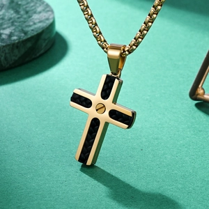 Goldenes Edelstahl-Kreuz mit schwarzem Lederinlay auf grünem Marmor-Hintergrund