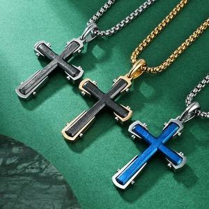 Trois colliers avec pendentif croix en acier brossé doré, argenté et bleu sur socle marbre