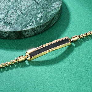 Men's gold steel bracelet featuring black carbon fiber inlays and V-groove faceted links