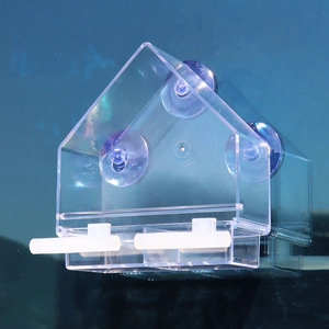 Macro shot of acrylic bird feeder with three suction cups and dual white perches