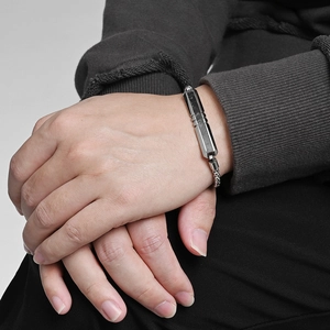 Polished stainless steel ID bracelet with bead chain on male model wearing grey sweater