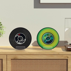 Clear acrylic book stand displaying vinyl records against a minimalist home background