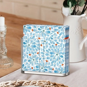 Detailed view of a clear acrylic napkin holder with floral napkins on a wooden table