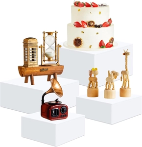 Macro view of white acrylic cube display risers for cakes and figurines with hollow bottom