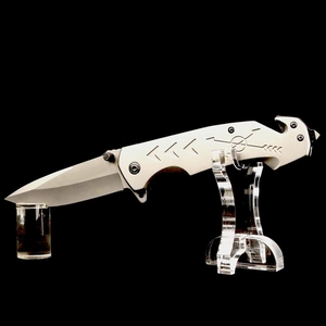 Tactical folding knife with engraved handle on acrylic display stand for home decor