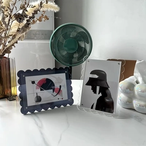 Close-up of modern wavy acrylic photo frame with blue tint and metal screw fasteners