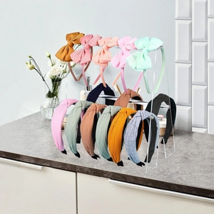 Macro detail of headband storage rack showcasing assorted colorful bows and knotted hairbands